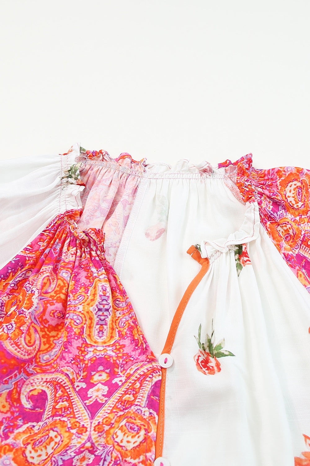 Close-up of a printed V-neck blouse featuring vibrant colors and button details.