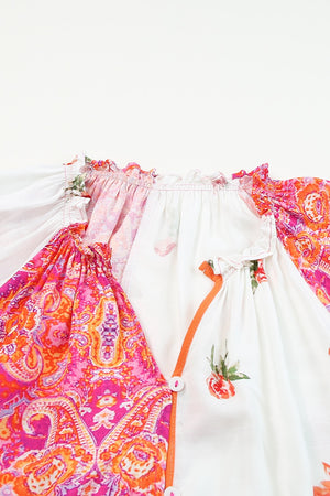 Close-up of a printed V-neck blouse featuring vibrant colors and button details.