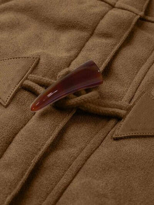 Close-up of toggle fastener on a brown pocketed long sleeve hooded jacket.