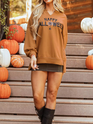 Model wearing a Happy Halloween graphic long sleeve top with pumpkins in the background, perfect for festive fall style.