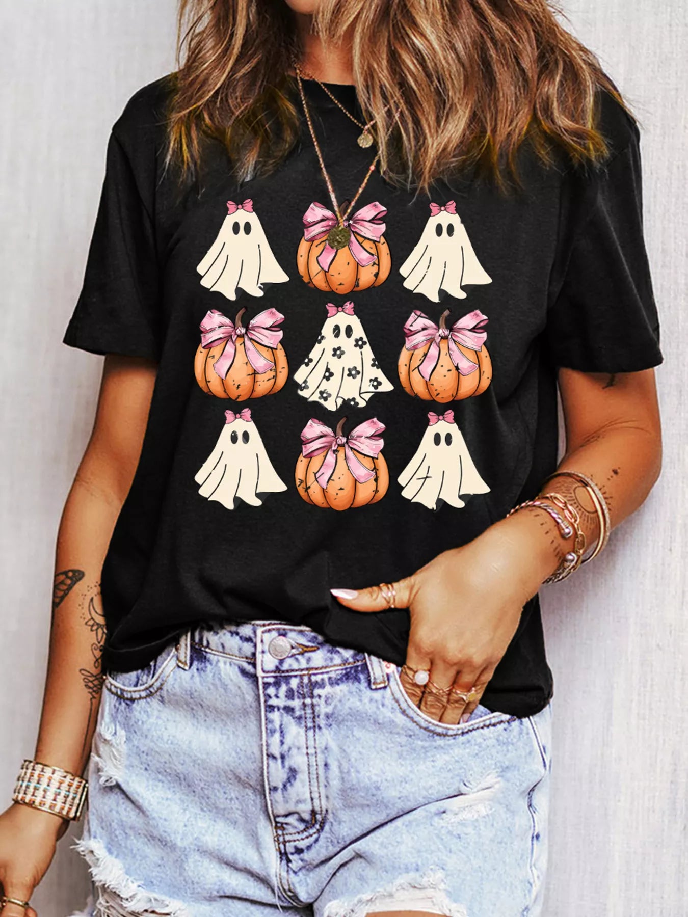 Halloween Bowknot Ghost Pumpkin Graphic T Shirt featuring playful designs in a black tee.