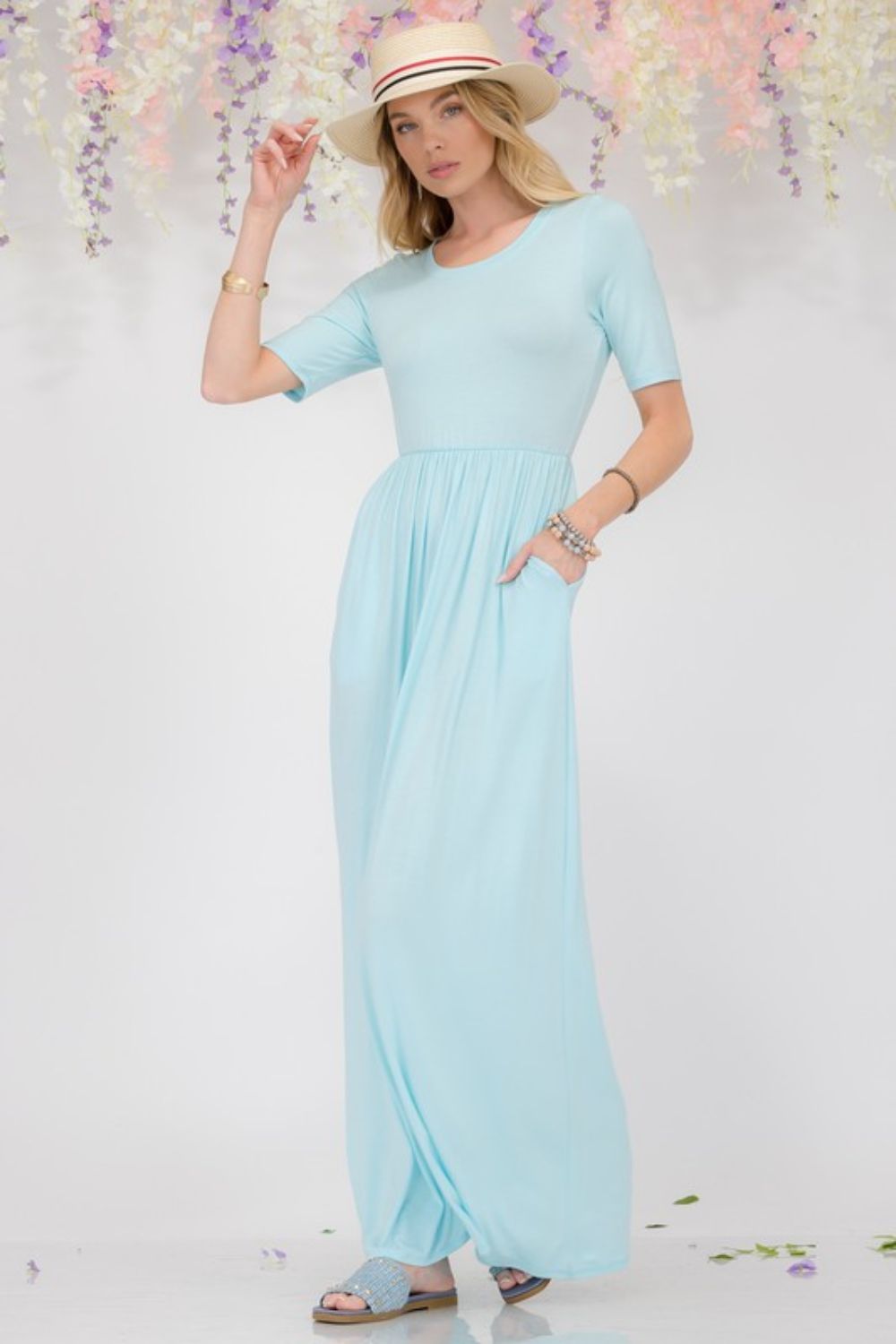 Celeste Plus Size Maxi Dress in light blue, featuring short sleeves, round neck, and convenient pockets, perfect for any occasion.