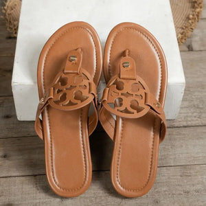 Brown toe post flats sandals with decorative cut-out design on straps, made of PU leather and rubber.