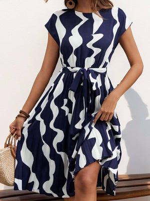 Tied pleated printed cap sleeve dress in navy and white with a flowy silhouette and stylish tie waist.