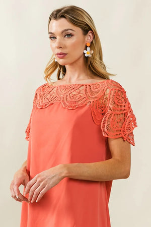 Stylish woman wearing a coral BiBi Crochet Lace Yoke Dress with intricate lace detailing for a chic look.