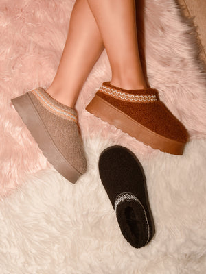 Cozy WILD DIVA embroidered trim platform sherpa boots in beige, brown, and black displayed on fuzzy surface.
