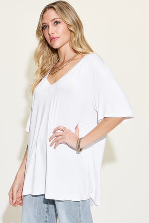 Woman wearing a white Basic Bae bamboo v-neck drop shoulder t-shirt with sleeves, styled for casual look.