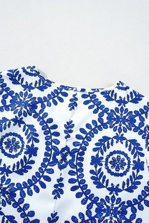 Close-up of a printed crew neck sleeveless top in blue and white featuring intricate floral patterns.