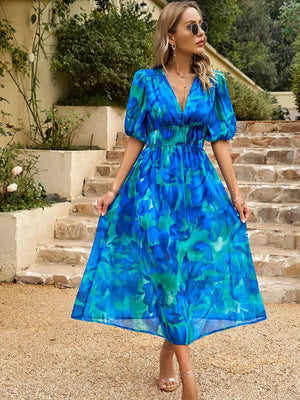 Model wearing a vibrant blue printed puff sleeve midi dress, perfect for stylish summer outings.
