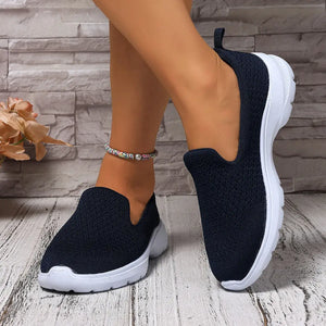 Lightweight breathable mesh slip-ons in navy blue worn with ankle bracelet, showcasing comfort and style.