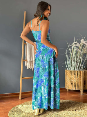 Back view of a woman wearing a Twisted Printed V-Neck Cami Dress with tropical leaf pattern in teal and green.