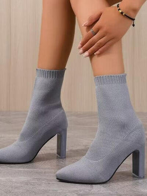 Pointed toe block heel boots in light gray with a sleek design, perfect for stylish outfits. High heel height for a chic look.