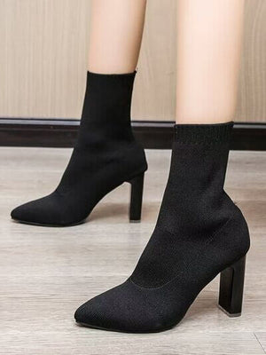 Stylish point toe block heel boots in black, featuring a sock-like design and high heels, perfect for chic outfits.
