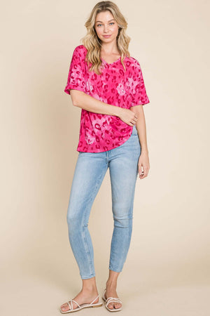 Model wearing a pink leopard print V-neck short sleeve T-shirt paired with light blue jeans, perfect for casual style.
