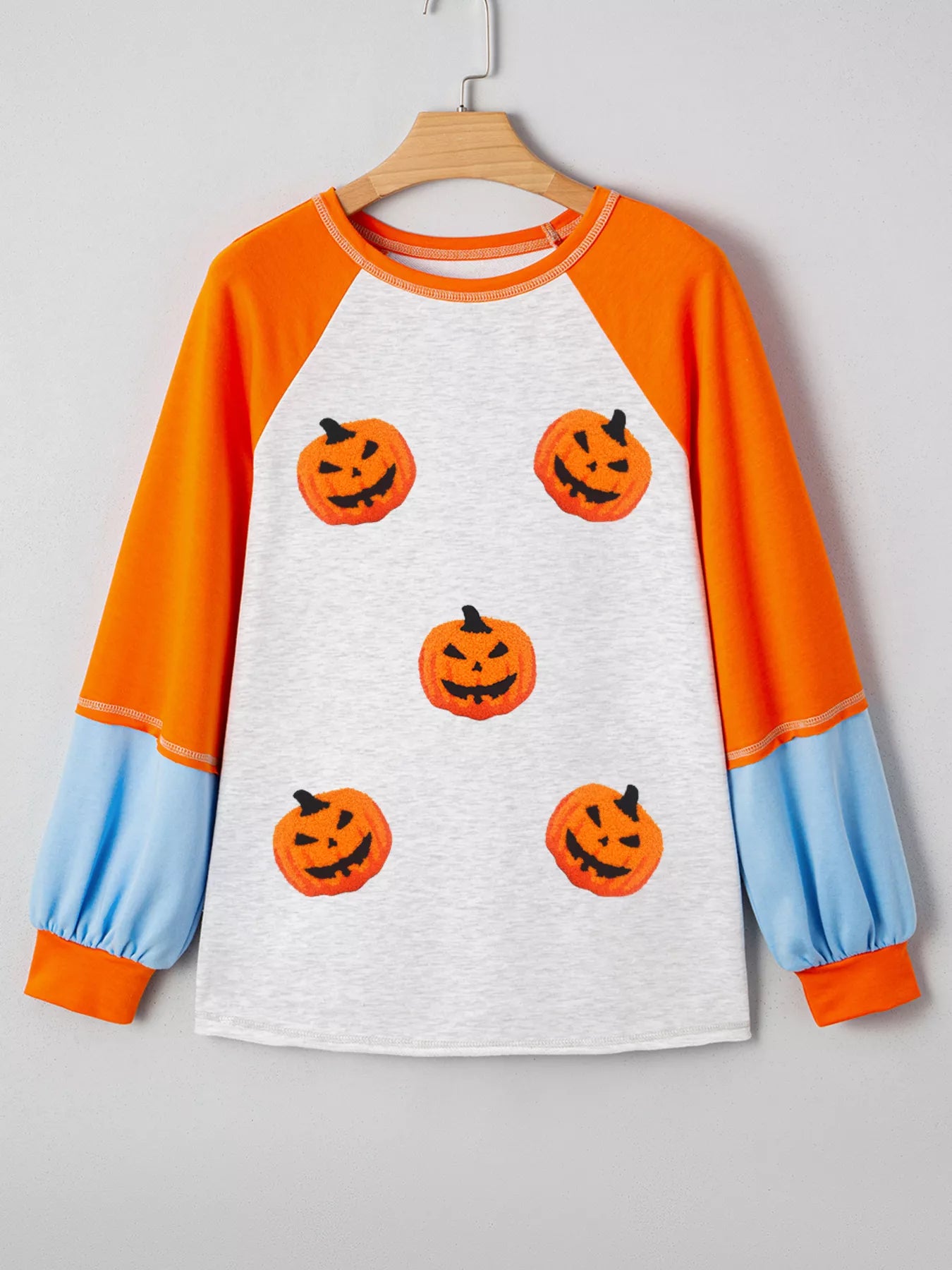 Halloween pumpkin print long sleeve t-shirt with orange sleeves and blue accents, perfect for festive fall celebrations.