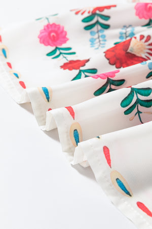 Close-up of floral print fabric with vibrant colors and ruffle trim details, perfect for stylish blouses.