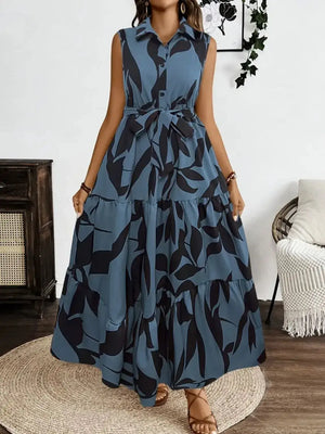 Stylish printed tie waist sleeveless maxi dress in blue with leaf pattern, perfect for casual occasions.