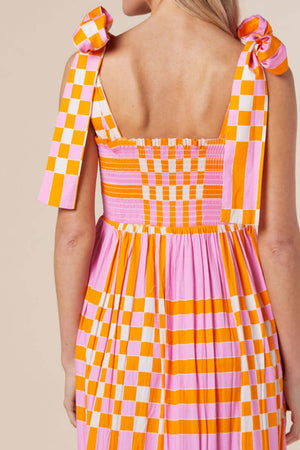 Back view of the Color Block Tie Shoulder Dress featuring bright pink and orange checkered patterns and tied shoulder straps.