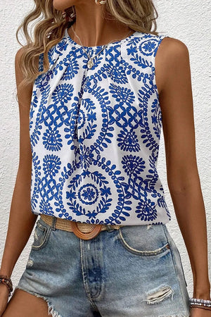 Printed crew neck sleeveless top in blue floral pattern, styled with denim shorts, perfect for a casual summer look.