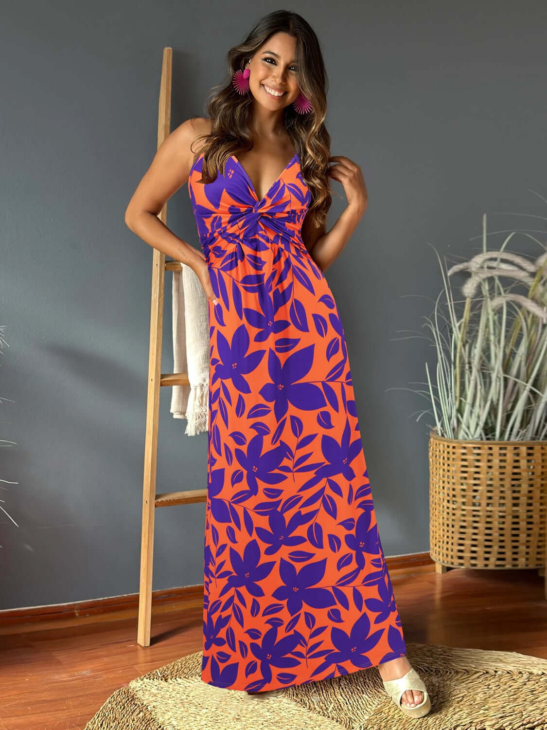 Model wearing a Twisted Printed V-Neck Cami Dress in vibrant orange and purple floral pattern, perfect for summer occasions.