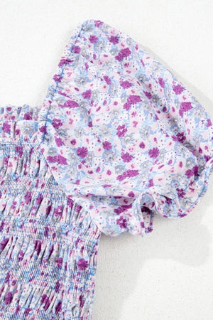 Detail of tiered floral shirred fabric showcasing purple and blue flowers on a light background.