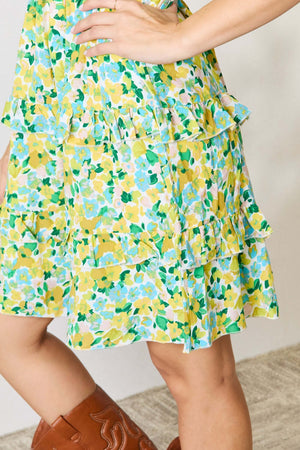 Floral mini dress with smocked details and ruffled flounce sleeves in vibrant yellow and green patterns, showcasing playful style.