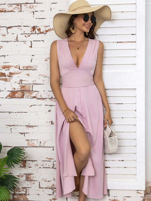 Full size pink slit V-neck sleeveless midi dress with a ruffle hem, styled with a wide-brim hat and sunglasses.