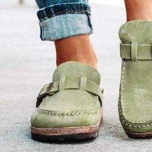 Green round toe low heel buckle loafers paired with rolled-up jeans, perfect for casual style.