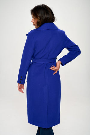 Back view of a woman in a blue double-breasted longline coat with belt, showcasing elegant tailoring and stylish design.