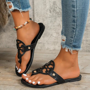 Stylish toe post flats sandals in black, perfect for summer, worn with distressed blue jeans and a chic anklet.