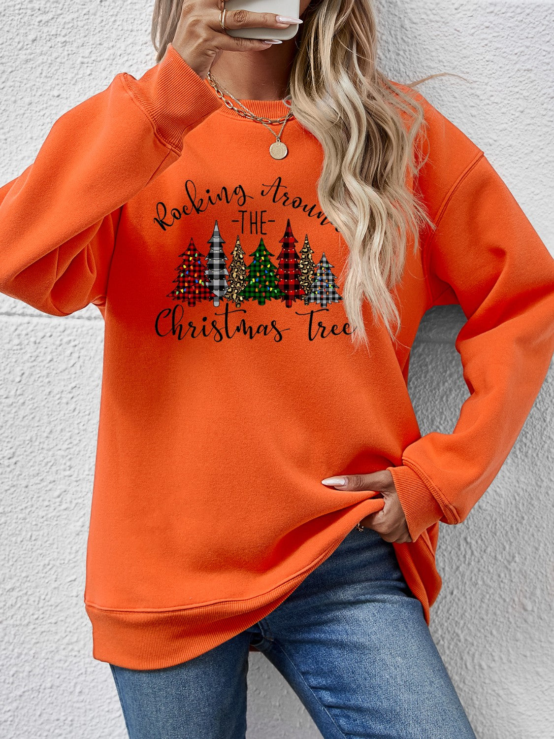 Orange Christmas tree graphic sweatshirt with text 'Rocking Around the Christmas Tree', cozy style for holiday wear.