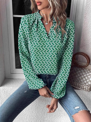 Printed notched long sleeve blouse in green pattern, styled with jeans and layered necklaces.