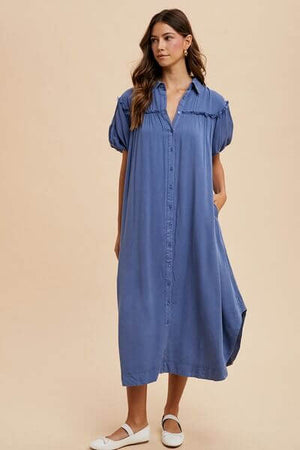 Model wearing a blue mineral washed button down puff sleeve shirt dress, showcasing a stylish and comfortable look.