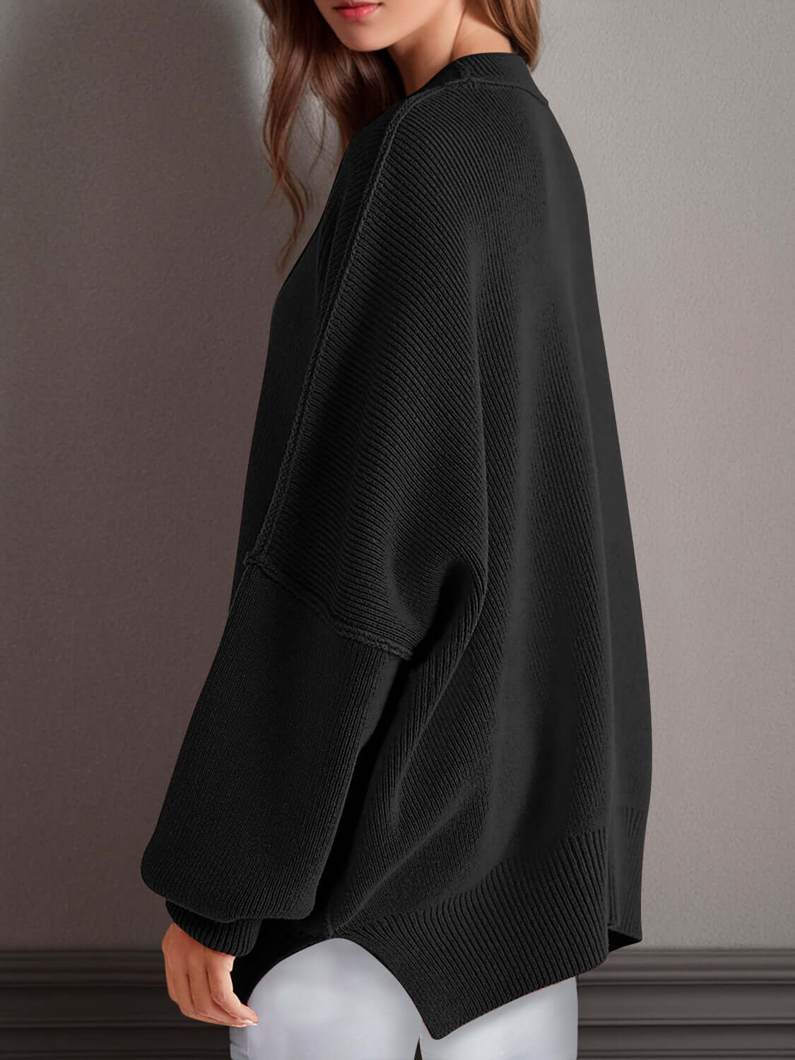 Chic side-slit sweater in black, featuring a cozy round neck and relaxed fit for ultimate comfort and style.