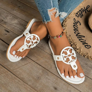 White toe post flats sandals with decorative detail, perfect for casual summer outfits.