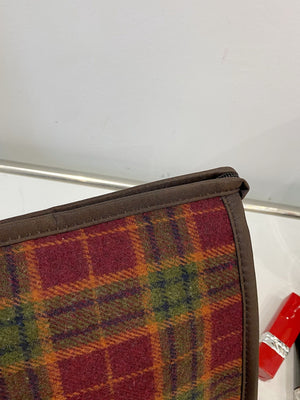 Close-up of a small contrast plaid clutch with zipper, featuring warm colors and a stylish design.