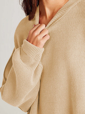 Close-up of a chic beige sweater with ribbed texture and cozy round neck, showcasing soft and comfortable fabric.