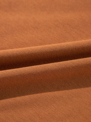 Close-up of soft brown fabric showcasing textures and folds, ideal for comfortable clothing.