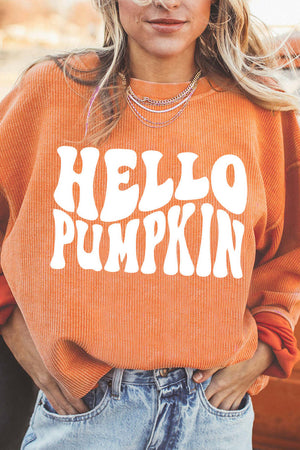 Person wearing a casual orange HELLO PUMPKIN graphic sweatshirt with long sleeves and round neck.