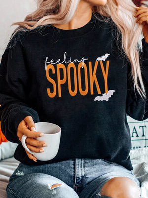 Black sweatshirt with 'Feeling Spooky' text and bats, perfect for Halloween style.