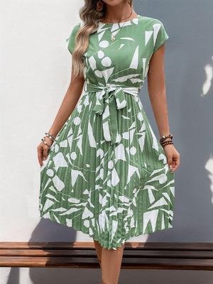 Tied pleated printed cap sleeve dress in green with white geometric patterns, perfect for summer wear.