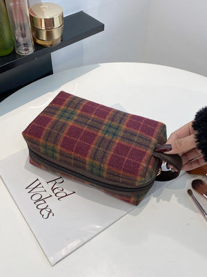 Small contrast plaid clutch bag with zipper, featuring a rich burgundy and green pattern, stylish and versatile accessory.