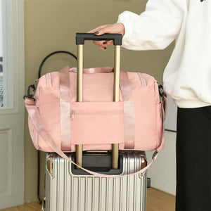 Oxford cloth travel bag with detachable strap, being pulled on a suitcase, perfect for oversized travel needs.