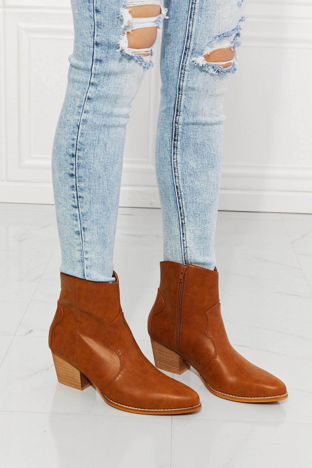 Ochre faux leather Western ankle boots with block heel paired with distressed jeans.