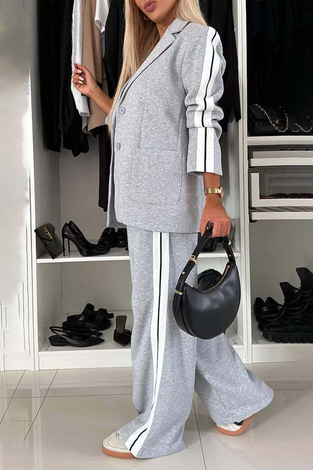 Woman wearing a full size contrast lapel collar top and pants set in gray with white stripes, styled with a black handbag.