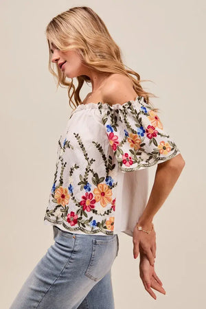 Floral embroidered two-way off the shoulder blouse with ruffled sleeves, perfect for versatile day-to-night looks.