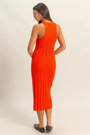 Back view of a woman wearing an orange ribbed bodycon dress, showcasing its flattering silhouette and stylish texture.