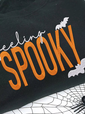 Feeling Spooky Halloween embroidered sweatshirt with bats design on a black background.