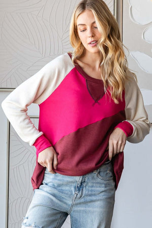 Model wearing a HOPELY color block long sleeve T-shirt in bold pink and maroon with casual jeans.
