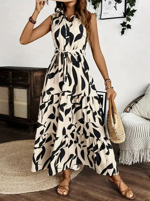 Stylish sleeveless maxi dress with tie waist and leaf print, perfect for summer outings and casual wear.